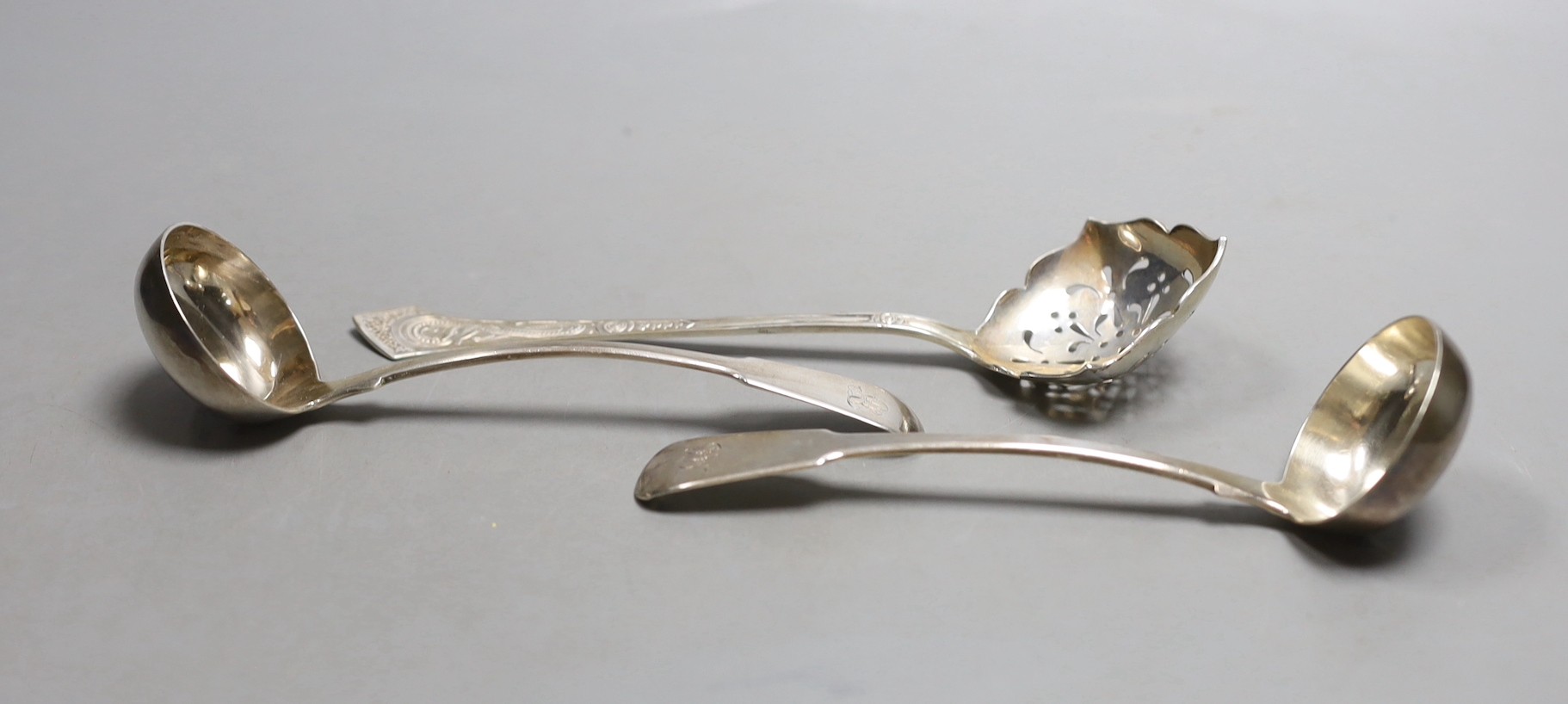 A pair of George IV Scottish silver fiddle pattern toddy ladles, James Mackay, Edinburgh 1827, and a Danish white metal sifting spoon.